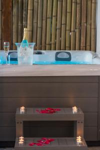阿達瑪斯的住宿－Kallia's Suites Milos，浴缸配有一瓶葡萄酒和一张带灯光的桌子
