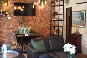 a dining room with a table and a television on a brick wall at Villa ANTONA in Prkos