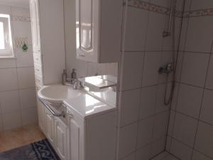 a white bathroom with a sink and a shower at Villa 2 Swans in Peroj +51 photos