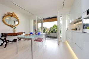 a white kitchen with a table and a mirror at Luxury Aurelia Apartment with Swimming Pool in Rome
