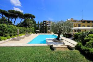 una piscina in un cortile alberato e un edificio di Luxury Aurelia Apartment with Swimming Pool a Roma