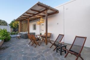 a patio with chairs and a table and a grill at Kallia's Suites Milos in Adamas