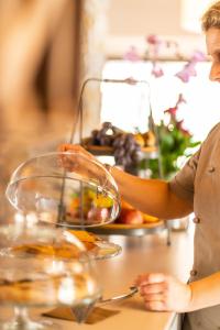 a woman standing at a table with a plate of food at Il Pradicciolo Agriturismo in Castelnuovo di Garfagnana