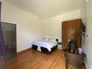 1 dormitorio pequeño con 1 cama y suelo de madera en Green Mountain Homestay - Birthi Falls near Munsyari, en Munsyari