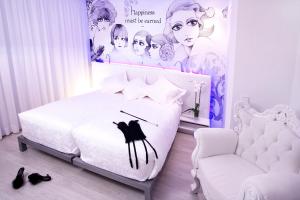 um quarto com uma cama branca e uma cadeira em Dormirdcine em Madrid mais 41 fotografias