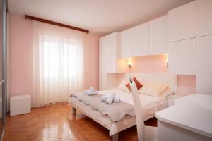 a bedroom with a large bed with white cabinets at Spacious Green Home in Hvar