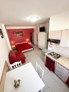 una cucina e un soggiorno con tavolo e divano di Monolocale Rosso - A casa di Ludovica e Martina a Gallipoli