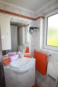 ein Bad mit einem weißen Waschbecken und einem Fenster in der Unterkunft Pension Sonnenschein in Sankt Kanzian am Klopeiner See