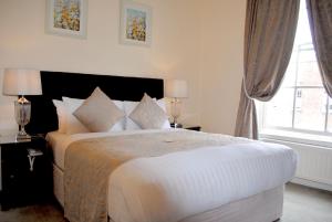 a bedroom with a large white bed and a window at Fitzwilliam Townhouse in Dublin