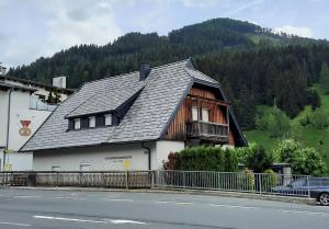 una casa con techo de gambrel al lado de una calle en Ferienwohnungen Fryba, en Bad Kleinkirchheim