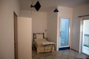 Schlafzimmer mit einem Bett und einer Tür zu einem Balkon in der Unterkunft Ιlias rooms in Patras