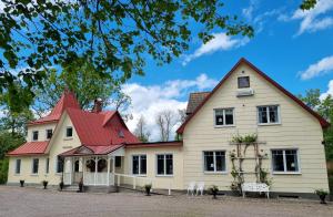 a large white house with a red roof at Villa Granliden in Ludvigsborg