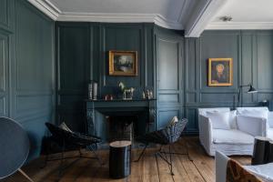 La Maison Pavie في دينان: غرفة معيشة مع أريكة ومدفأة