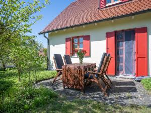 une table et des chaises devant une maison dans l'établissement Feriendorf Rugana - Komfortplus Appartement mit 1 Schlafzimmer und Terrasse B43, à Dranske