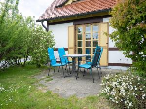 ein Tisch und Stühle vor einem Haus in der Unterkunft Feriendorf Rugana - Klassik Appartement mit 2 Schlafzimmern und Terrasse D01 in Dranske