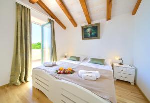 Dormitorio con cama blanca y bandeja de fruta. en Villa Bodulova, en Polje