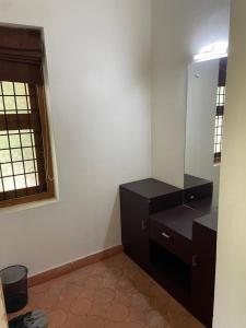 a bathroom with a black dresser and a mirror at Maleyam Homestay Riverside in Kozhikode