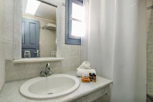 a bathroom with a sink and a mirror at Atlantis Beach Villa in Perivolos