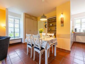 une cuisine et une salle à manger avec une table et des chaises dans l'établissement Feriendorf Rugana - Komfort Appartement mit 2 Schlafzimmern und Terrasse A61, à Dranske