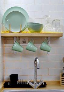 um lavatório de cozinha com canecas verdes numa prateleira em Studio Simon 1 Murcia em Múrcia