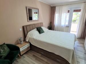 a bedroom with a bed and a chair and a mirror at M & M Apartment in Pula