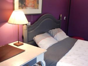 um quarto com uma cama e uma mesa com um candeeiro em Gîte à la campagne proche d'Angers et de la Loire em Saint-Martin-du-Fouilloux
