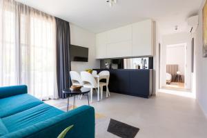 a living room with a blue couch and a kitchen at Villa Piano Residences in Vantačići