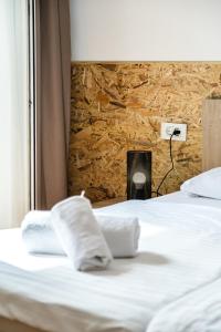 a bed with white sheets and a stone wall at Stay in Meta Mate in Split