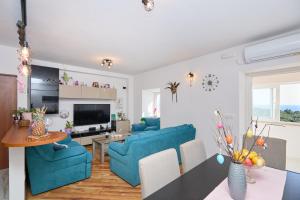 ein Wohnzimmer mit 2 blauen Stühlen und einem Tisch in der Unterkunft STIGA 4 - new 2 bedroom apartment in Babino Polje