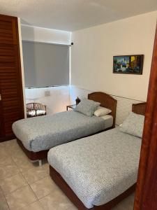 una camera con due letti e una sedia e una finestra di Fantastic Bungalow Playa de Las Américas ad Arona