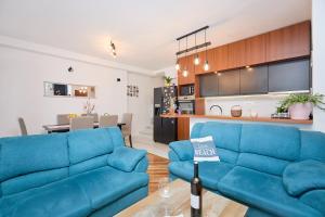 a living room with a blue couch and a kitchen at STIGA 4 - new 2 bedroom apartment in Babino Polje