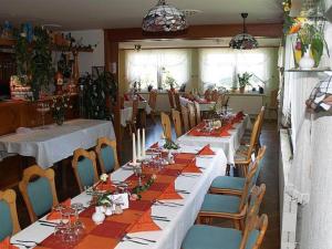 uma sala de jantar com mesas longas e cadeiras em Gasthaus Kobär em Kurort Altenberg