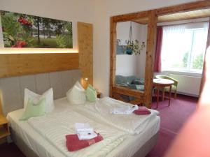 a bedroom with a bed with towels on it at Gasthaus Kobär in Kurort Altenberg