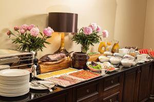 ein Buffet mit Speisen und Blumen auf dem Tisch in der Unterkunft Pałac Warlity in Hohenstein