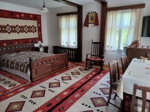 um quarto com uma cama, uma mesa e cadeiras em Pensiunea Agroturistica Casa Jucan em Poeni-Solca