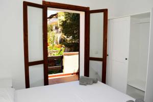 1 dormitorio con espejo, cama y ventana en Moderno e ampio trilocale, en Porto Pozzo