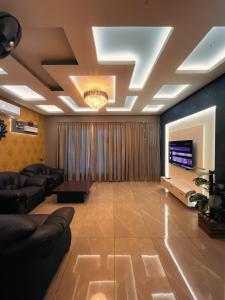 a living room with a couch and a television at BBC Luxury Apartments in Perintalmanna