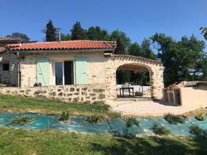 ein Steinhaus mit einem Tisch davor in der Unterkunft Gîte Le Malartic Gersois avec piscine in Montaut-les-Crénaux