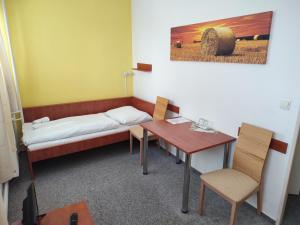 een kamer met een bed, een bureau en een tafel bij BEST Hotel Garni in Olomouc