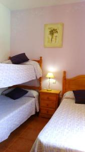 a bedroom with two beds and a table with a lamp at Bonito adosado playas Islantilla in Islantilla