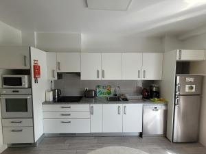 a kitchen with white cabinets and stainless steel appliances at StaynFeel 02 in Fátima