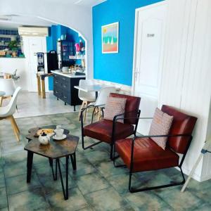 a living room with red chairs and a table at Hotel Alcyon in Valras-Plage