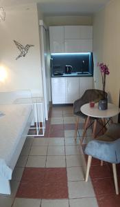 a small room with a table and a kitchen at Romir Pokoje Bardzo Gościnne in Sztutowo