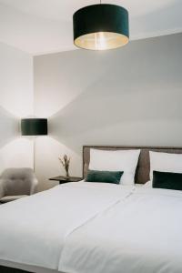 Un dormitorio con una gran cama blanca y una lámpara en St. Antoni Suite 7, en Eisenstadt