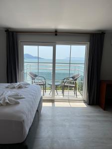 a bedroom with a bed and a view of the ocean at MIA CASA HOTEL in Fethiye