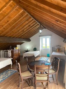 ein Zimmer mit Tisch und Stühlen und zwei Betten in der Unterkunft Green Sunrise House in Nordeste