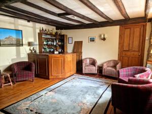 a room with a bar with chairs and a table at Collaven Manor in Okehampton