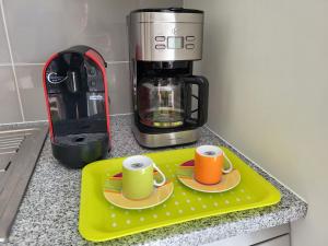 two cups on a tray next to a coffee maker at StaynFeel 02 in Fátima