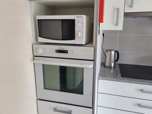 a microwave sitting on top of a oven in a kitchen at StaynFeel 02 in Fátima