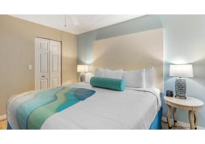 a bedroom with a large bed with a blue pillow on it at Via Roma Beach Resort in Bradenton Beach +17 photos